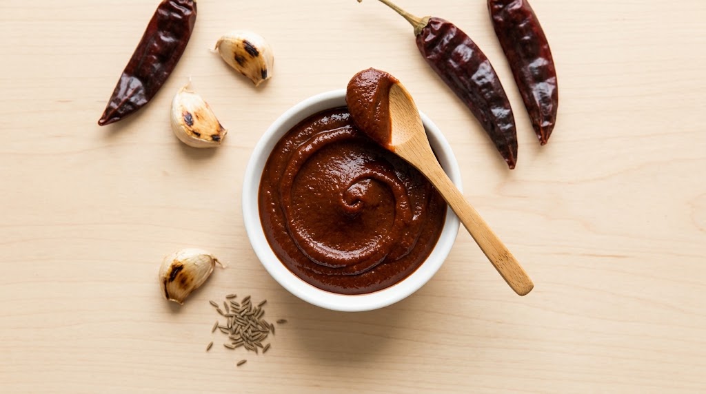 Aji Panca Paste Recipe: How to Make It at Home with Dried Chilies Aji panca paste recipe: homemade dark red chili paste in a white bowl with dried chilies